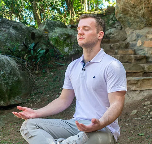 Guilherme Biotto em posição de meditação realizando autoaplicação de reiki.