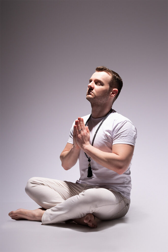 Guilherme Biotto com japamala meditando e praticanto terapias holísticas.